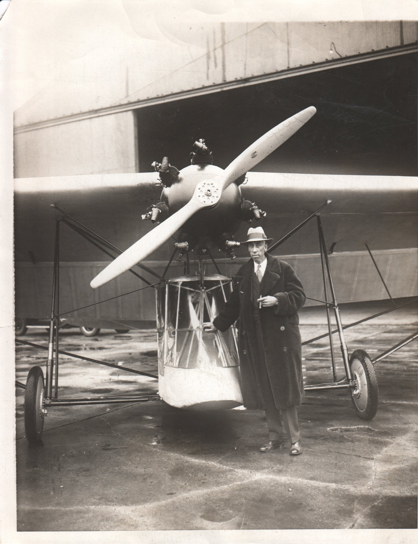 Vintage photograph of an early aircraft with a pilot standing beside it. - Image: Folder3-17