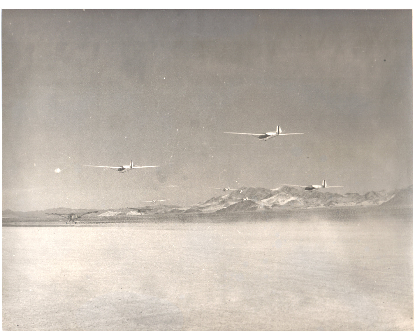 Vintage black-and-white photograph of aircraft flying over a desert landscape - Image: Folder18-7