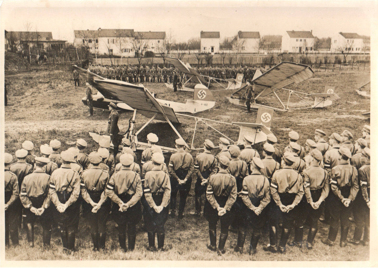 Black-and-white photograph of a WWII German military gathering with soldiers and vintage aircraft. - Image: Folder7-15