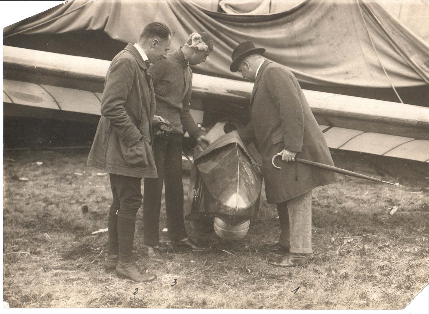 Vintage photograph of three men inspecting an early aircraft. - Image: Folder24-1