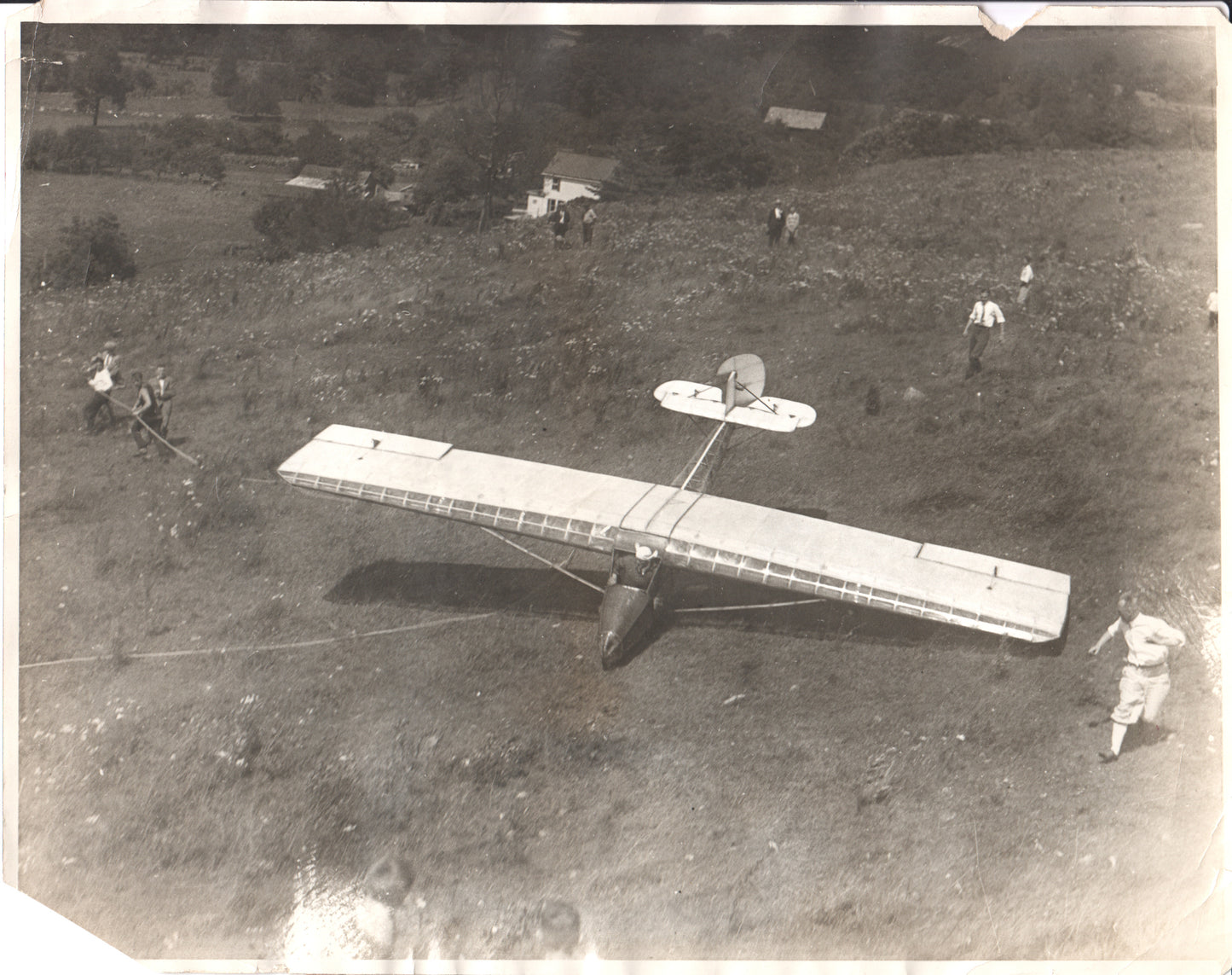 Vintage black and white photo of an early glider on a hillside with people preparing for flight. - Image: Folder20-9