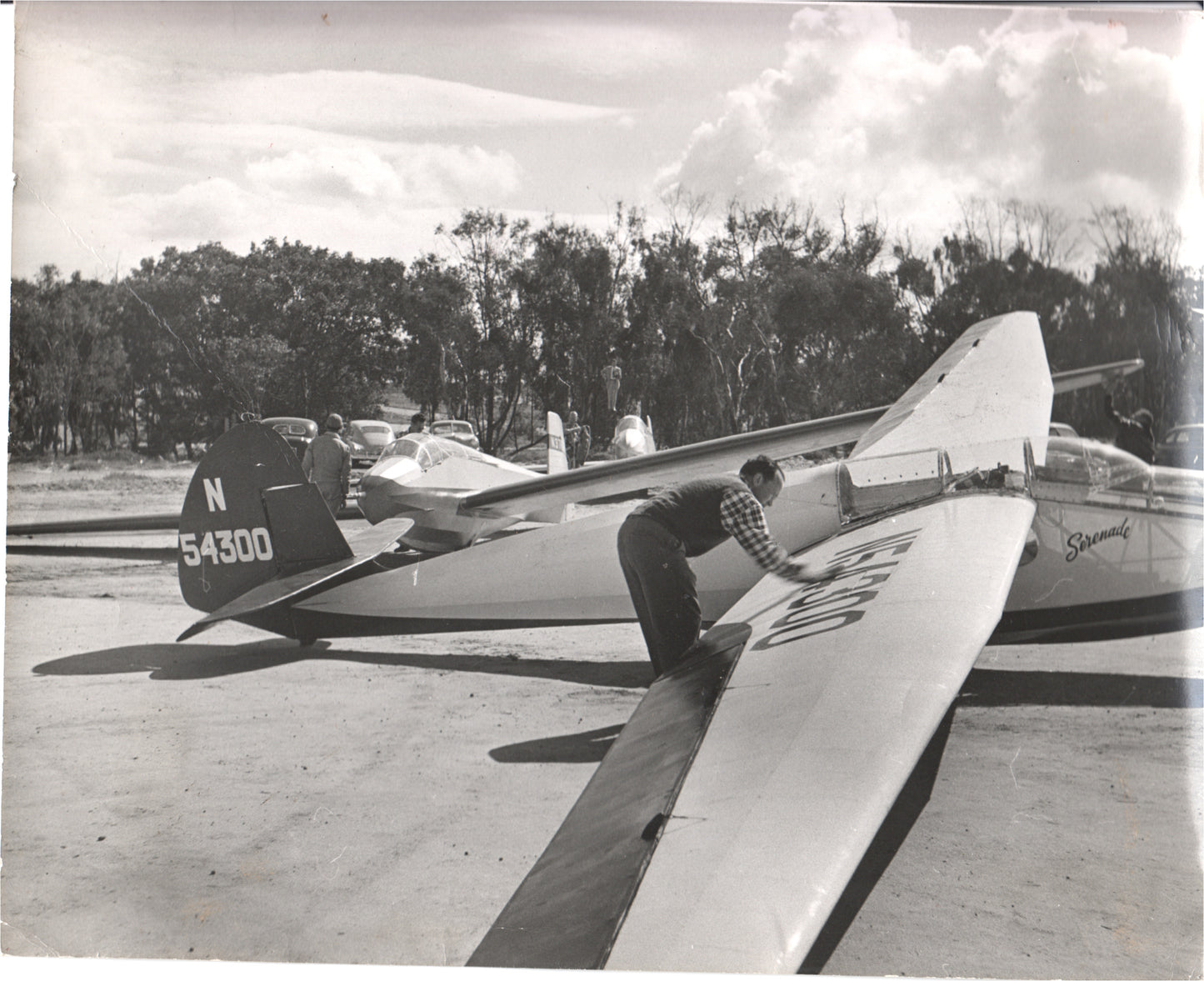 A pilot tuning a glider with tail number N54300 in a vintage photograph.