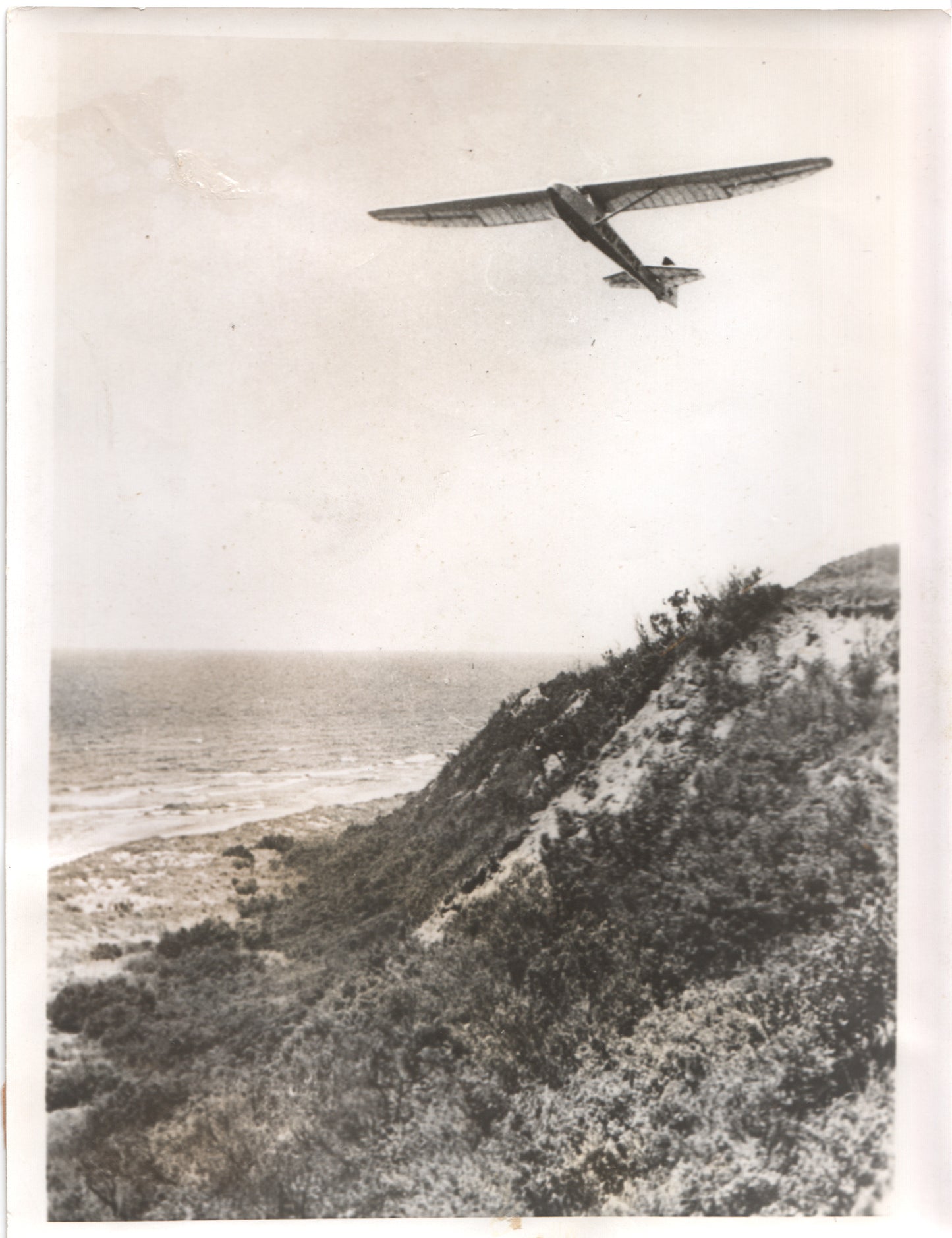 Vintage black and white photo of a glider flying over the coast. - Image: Folder17-3
