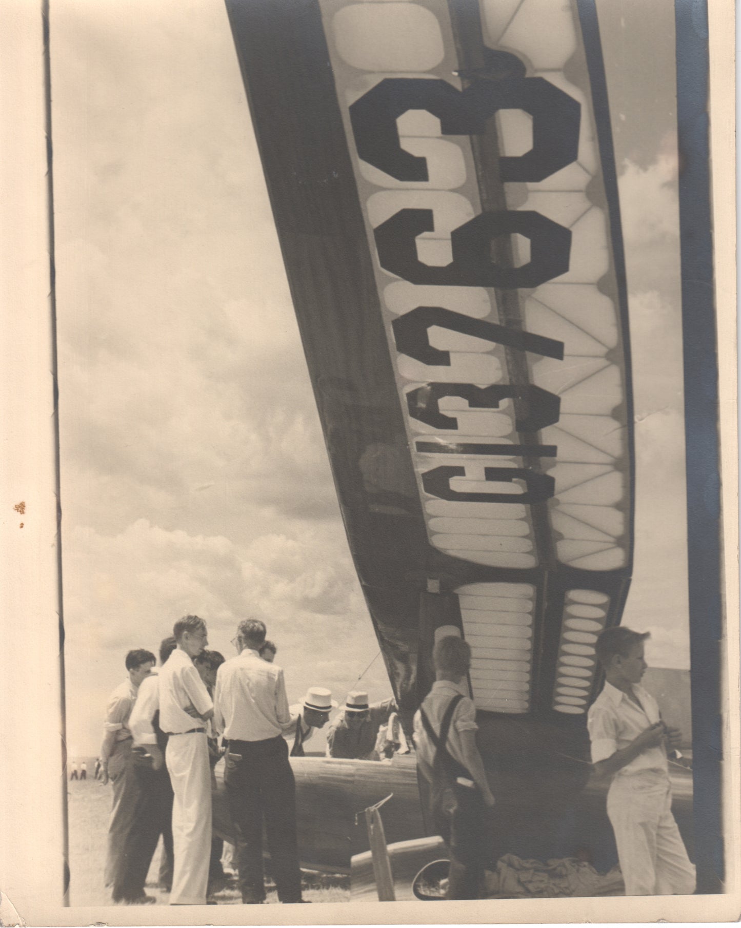 Black-and-white photograph of people gathered around a vintage aircraft. - Image: Folder18-10