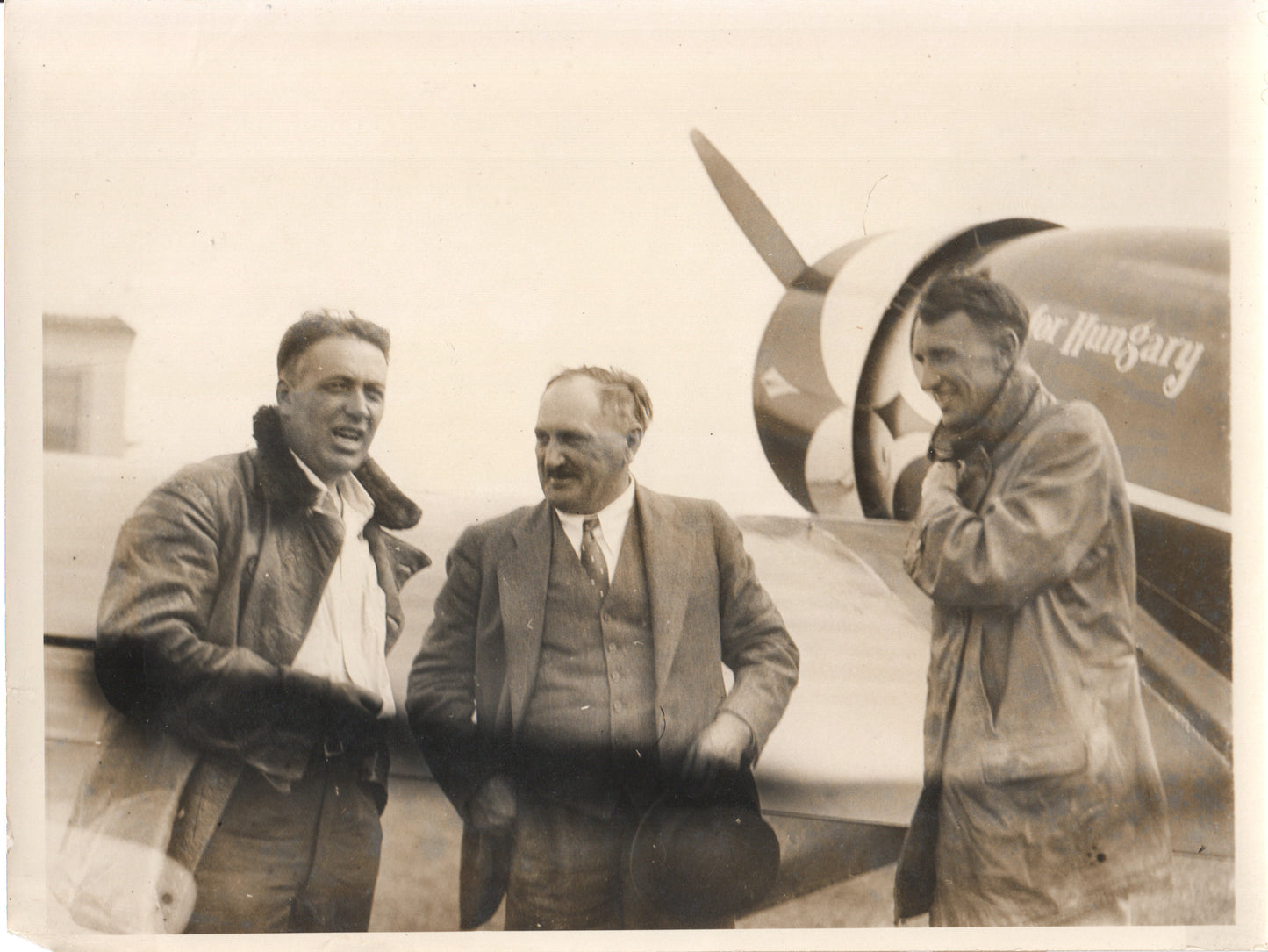 Vintage photograph of early aviation pioneers with an airplane propeller in the background - Image: Folder24-19