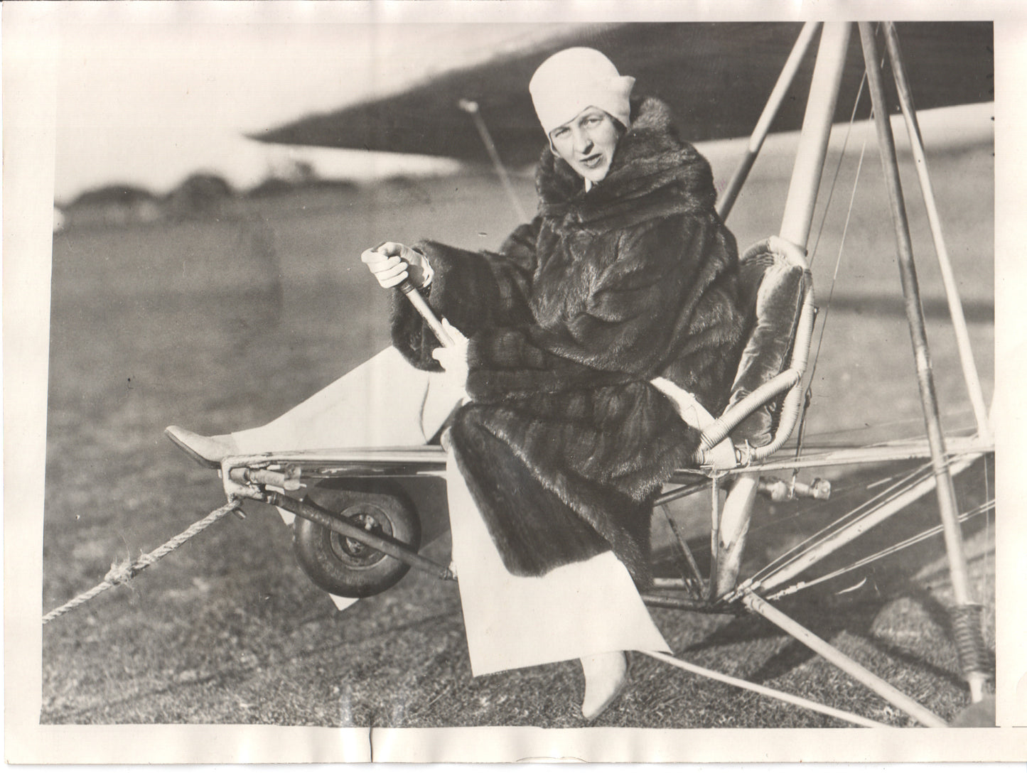 Vintage photo of a woman pilot in a fur coat sitting in a small aircraft. - Image: Folder24-3