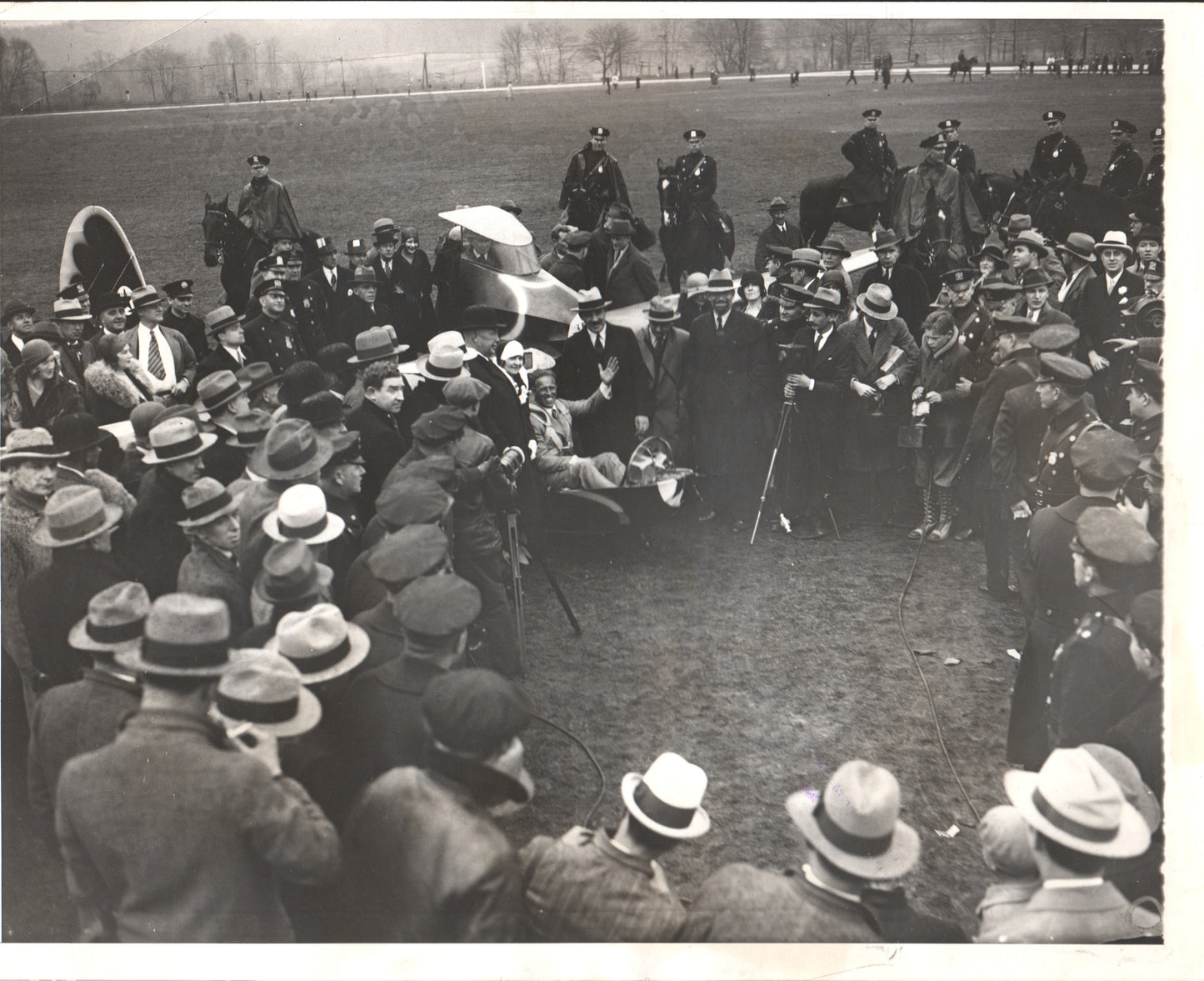 Black and white photo of a crowd gathered around an early airplane at an outdoor event. - Image: Folder3-15