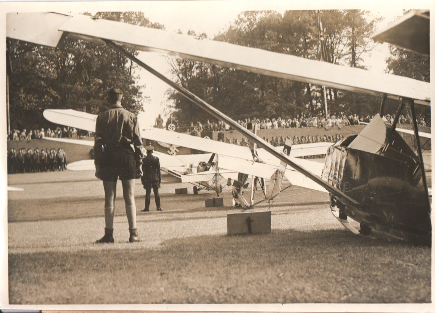 Early 20th-century air show with biplanes and military personnel in uniform. - Image: Folder3-9