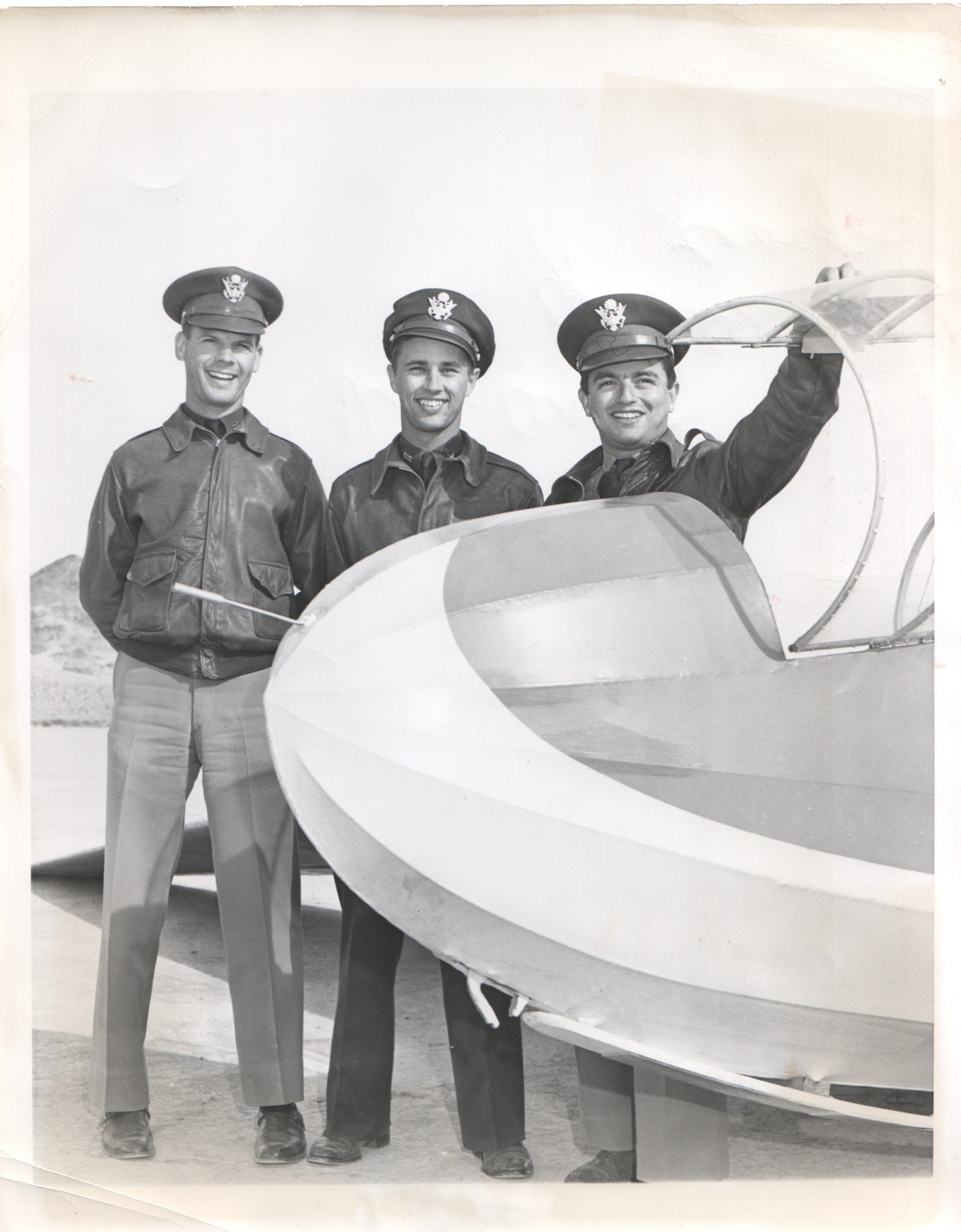 Three WWII pilots posing by an airplane in a vintage black and white photograph. - Image: Folder17-11