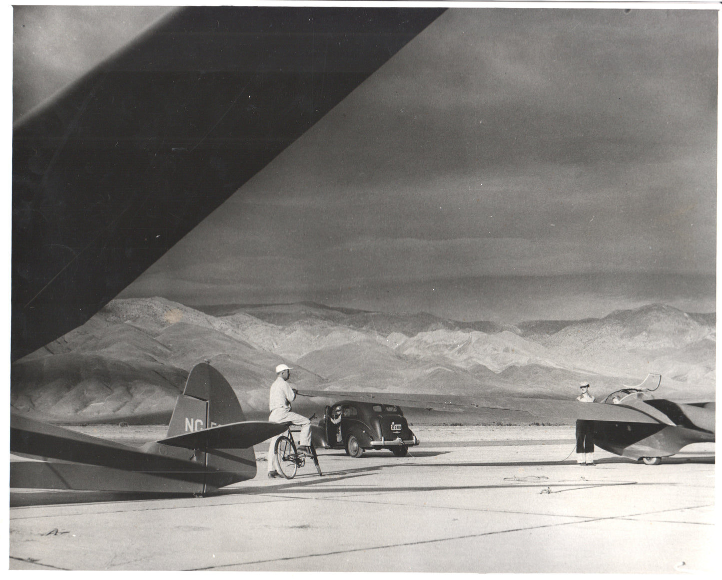 Black and white photo of gliders and a classic car at an airfield. - Image: Folder26-15