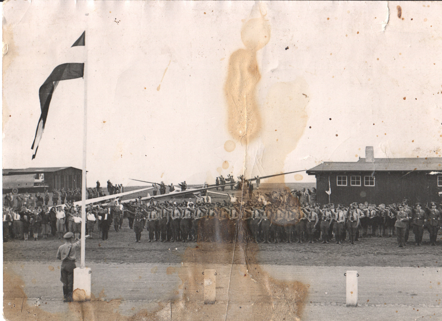 Vintage black and white photograph of a military parade with soldiers and a flag raising ceremony. - Image: Folder3-7