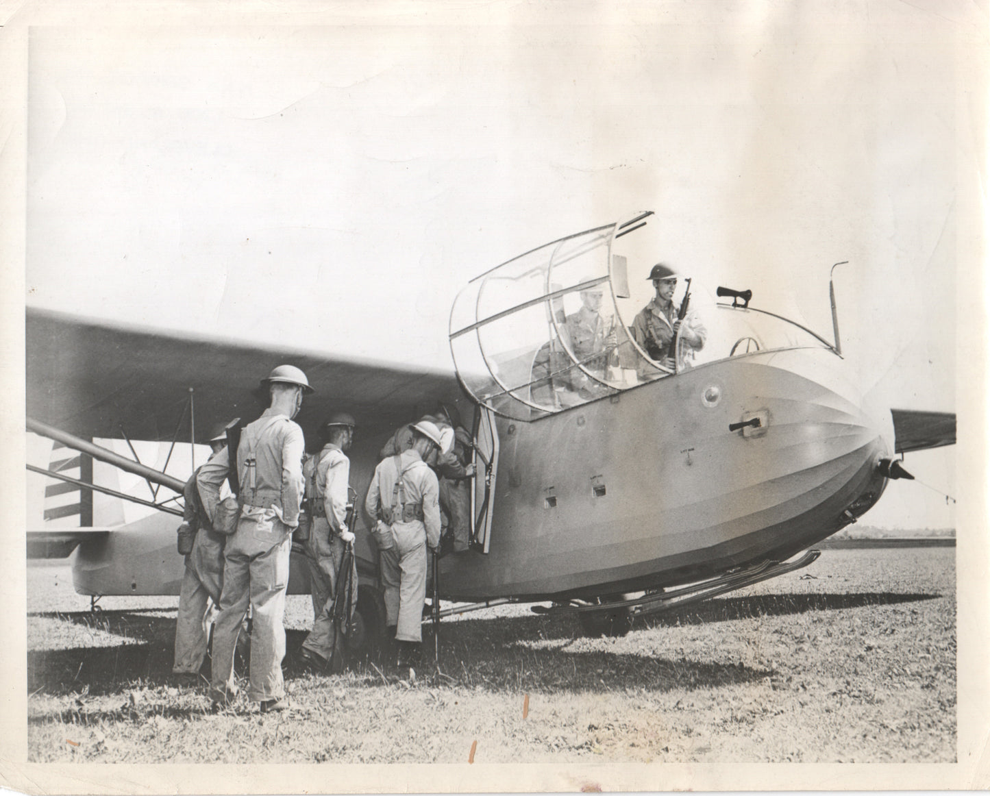 Military personnel boarding a vintage airplane in a black-and-white photograph. - Image: Folder16-25