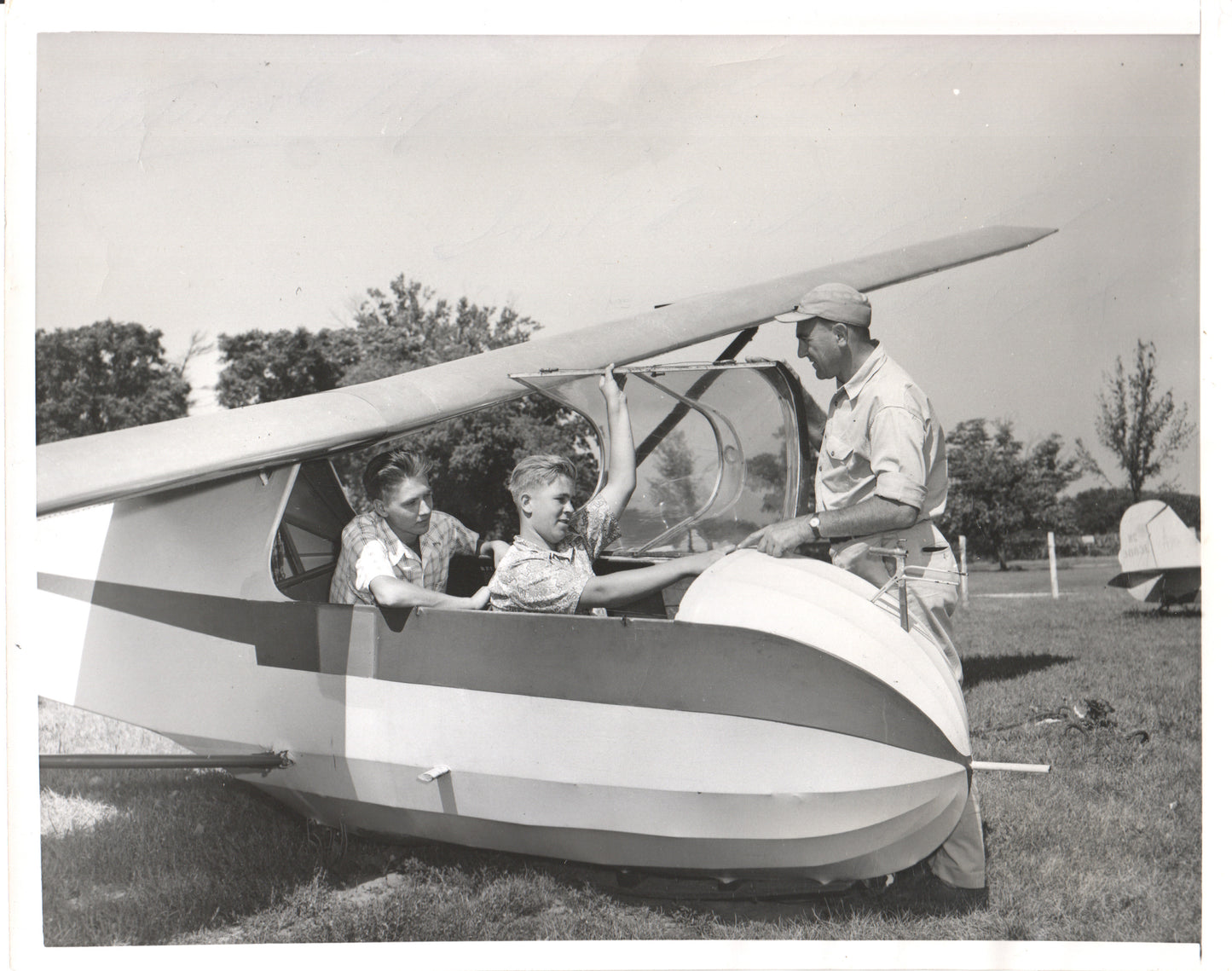Black and white vintage photograph of boys in a glider with an instructor. - Image: Folder23-8