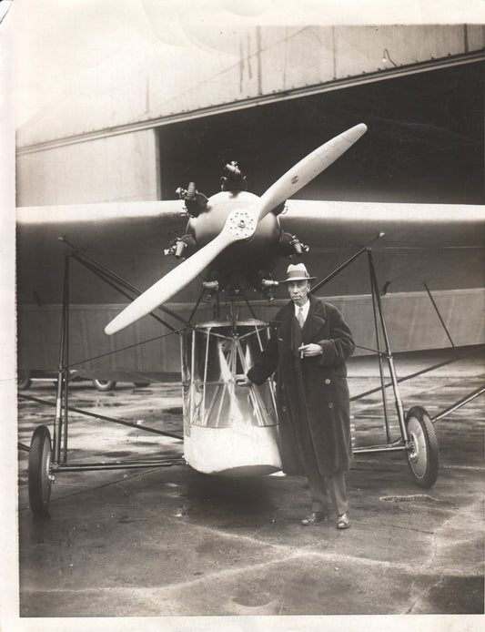 Vintage photograph of an early aircraft with a pilot standing beside it. - Image: Folder3-17