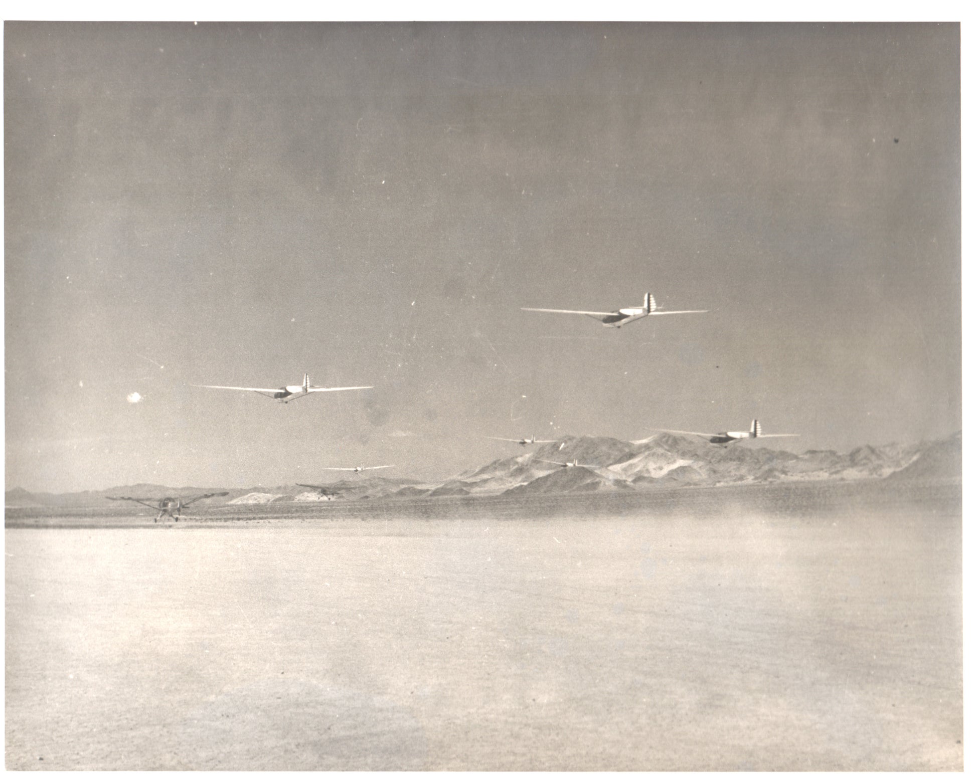 Vintage black-and-white photograph of aircraft flying over a desert landscape - Image: Folder18-7