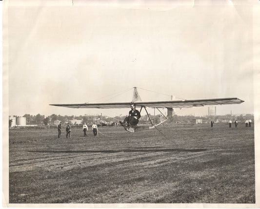 Black and white photograph of an early glider being flown with spectators in the background. - Image: Folder8-8
