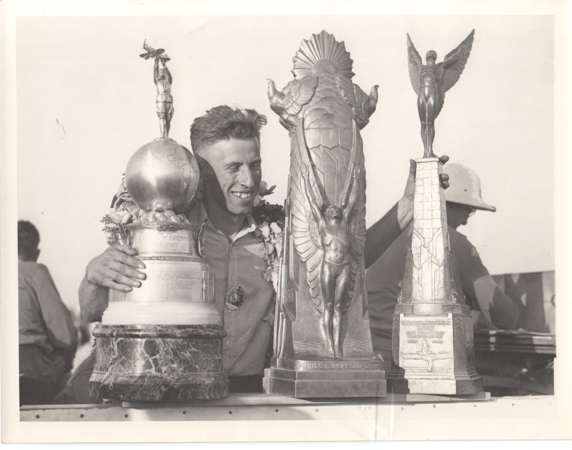 Vintage photograph of a man holding a collection of aviation trophies. - Image: Folder13-6