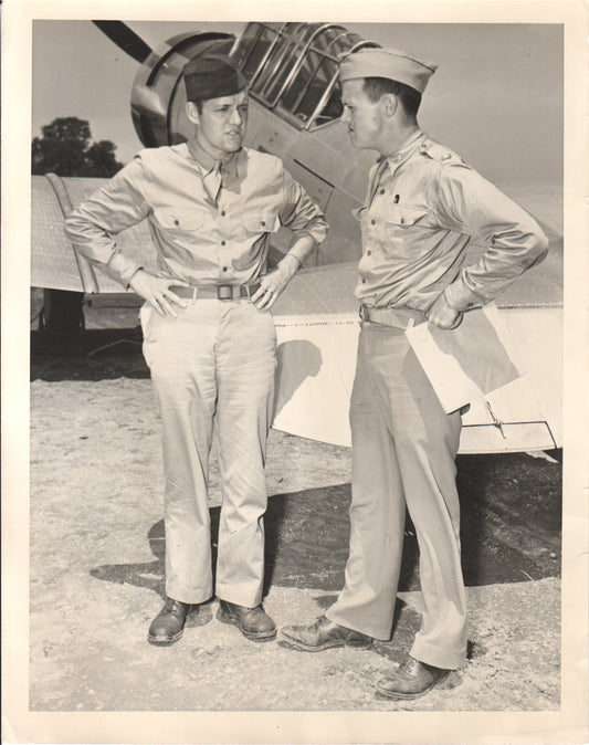 Two military personnel conversing near a WWII aircraft. - Image: Folder7-11