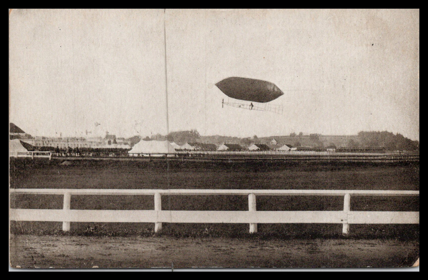 Vintage postcard depicting an airship flying over a field. - Image: MA-PC_0041