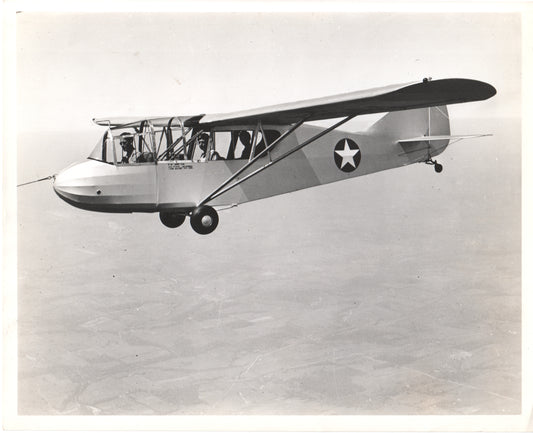 Vintage black-and-white photo of a Stinson L-5 Sentinel aircraft in flight. - Image: Folder26-9