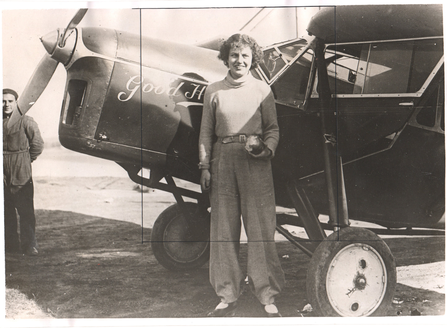 Vintage photograph of a female aviator standing beside an airplane. - Image: Folder12-11