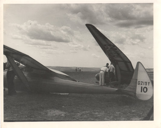 Vintage black and white photograph of a glider aircraft with people in the background. - Image: Folder18-11