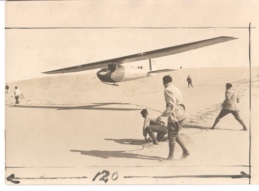 Black and white photo of a glider being launched with people on sandy dunes. - Image: Folder8-6