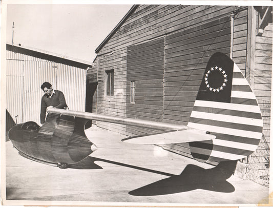 Black and white photo of a man with a prototype aircraft featuring a star-spangled design.