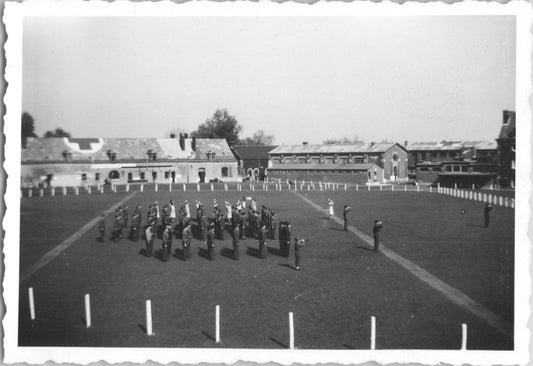 Black-and-white military formation photograph featuring soldiers and historic buildings. - Image: 2025-08-25-0024