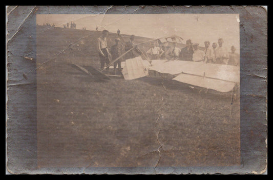 Vintage photograph of a group gathered around a homemade aircraft on a hillside. - Image: MA-PC_0031