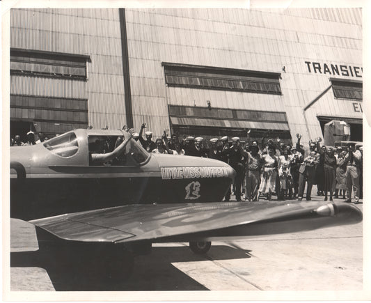 Vintage photo of "Little Miss Moffett" aircraft with a cheering crowd in front of a hangar. - Image: Folder9-11