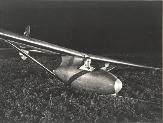 A pilot seated in a vintage wooden glider at night. - Image: Folder25-27