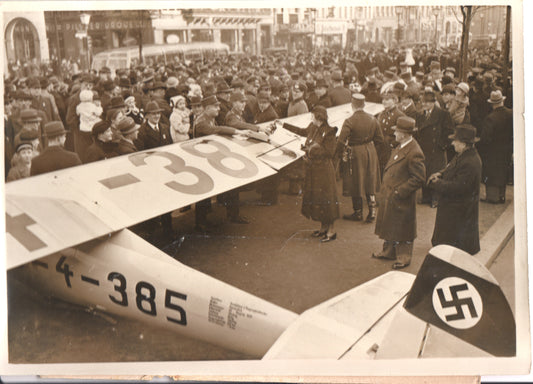 Historic 1930s photograph of a crowd gathered around an aircraft.