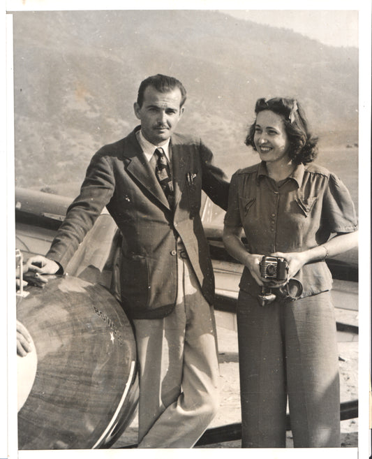 A stylish couple poses next to an aircraft in a vintage black and white photograph. - Image: Folder23-12