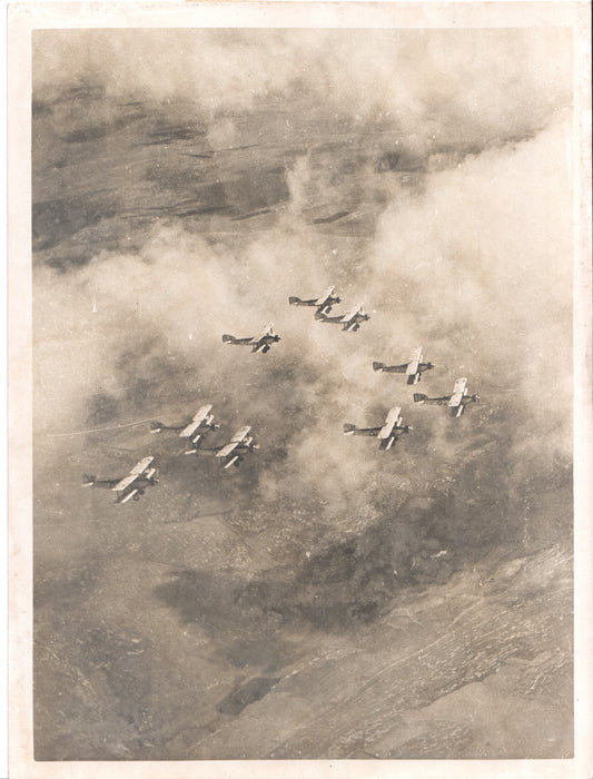 A vintage black-and-white aerial photograph of fighter planes in formation. - Image: Folder25-15