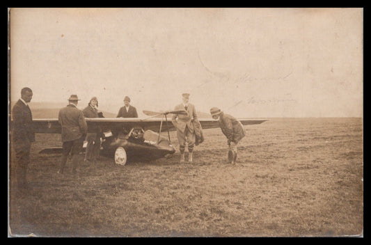 Vintage photograph of a group of aviators beside an early airplane in a grassy field. - Image: MA-PC_0005