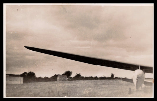 Vintage photograph of an aircraft with a wing in focus against a cloudy sky. - Image: MA-PC_0009