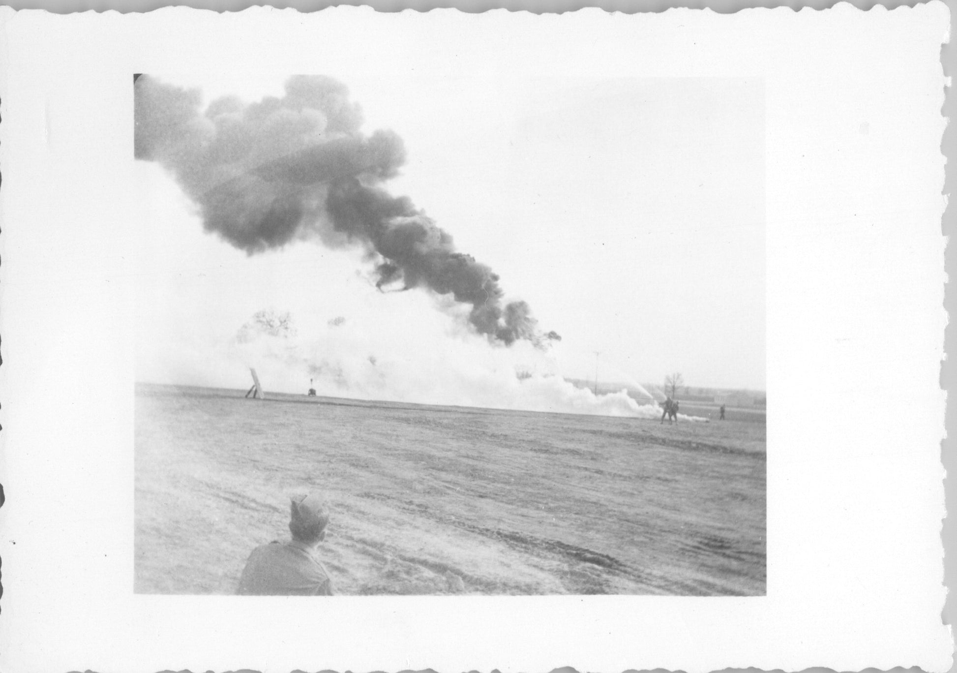 Black and white photo of a firefighting demonstration with smoke rising in the background. - Image: 2025-08-25-0061