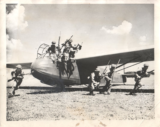 Black and white photo of WWII soldiers disembarking from a military glider. - Image: Folder16-27