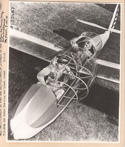 Vintage photograph of two military pilots in a two-place aircraft, depicting WWII-era aviation training. - Image: Folder21-9