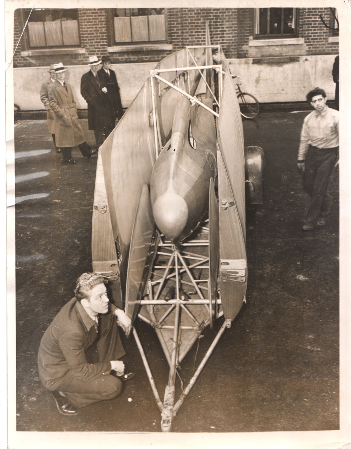 Black-and-white photo of a vintage aircraft model and designers in the 1930s. - Image: Folder14-7