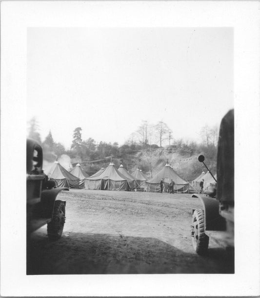 Black and white photograph depicting military tents and vintage vehicles in a camp setting. - Image: 2025-08-25-0068