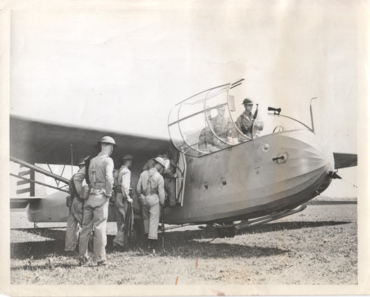 Military personnel boarding a vintage airplane in a black-and-white photograph. - Image: Folder16-25