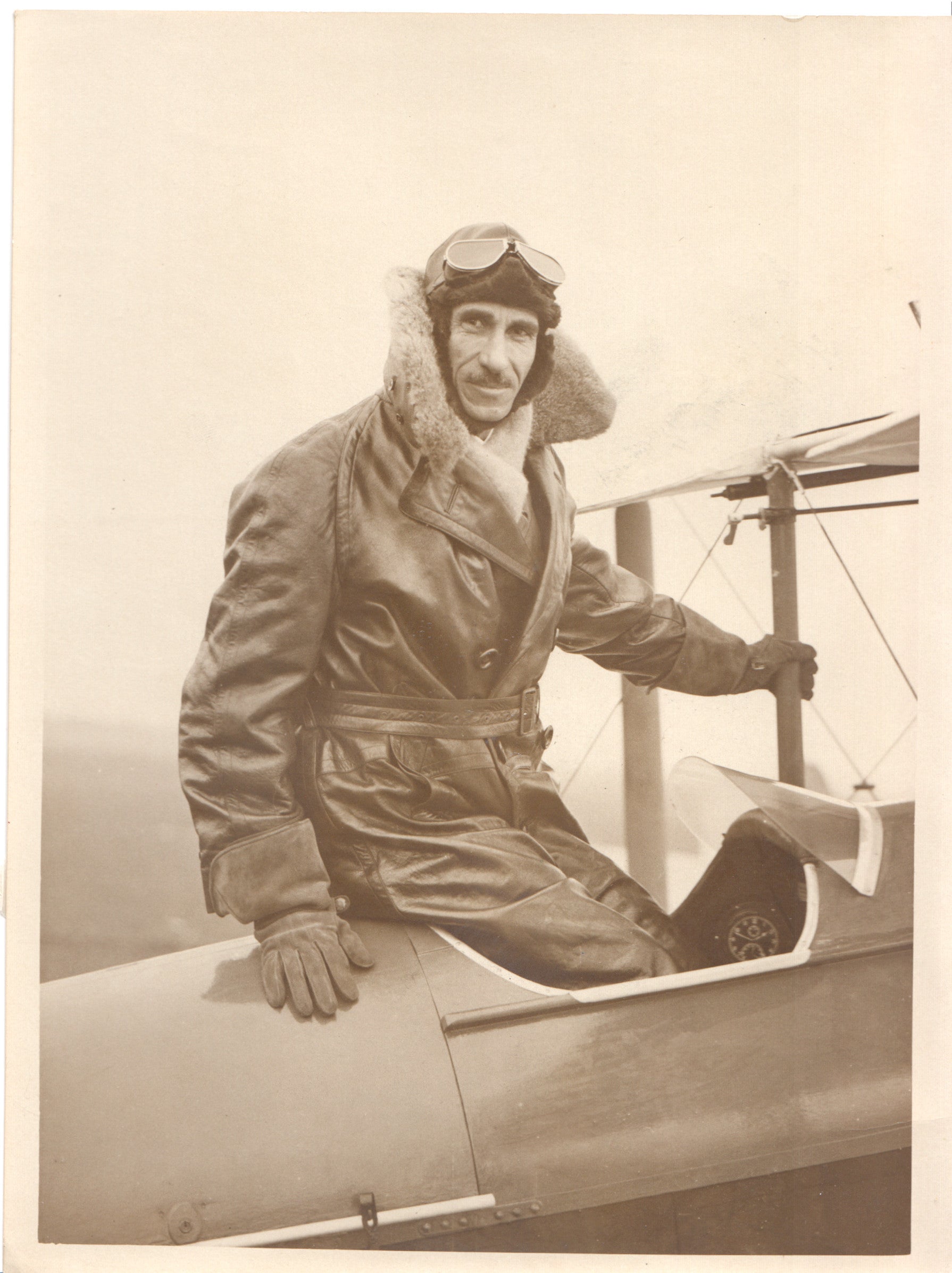 Vintage photograph of an aviator in a leather jacket sitting on a biplane. - Image: Folder28-19