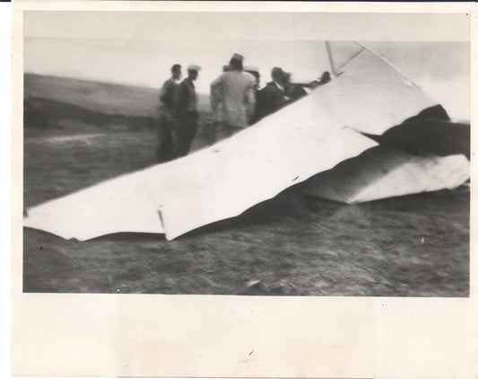 Historical black and white photograph of a glider incident with a group of people gathered around. - Image: Folder3-23