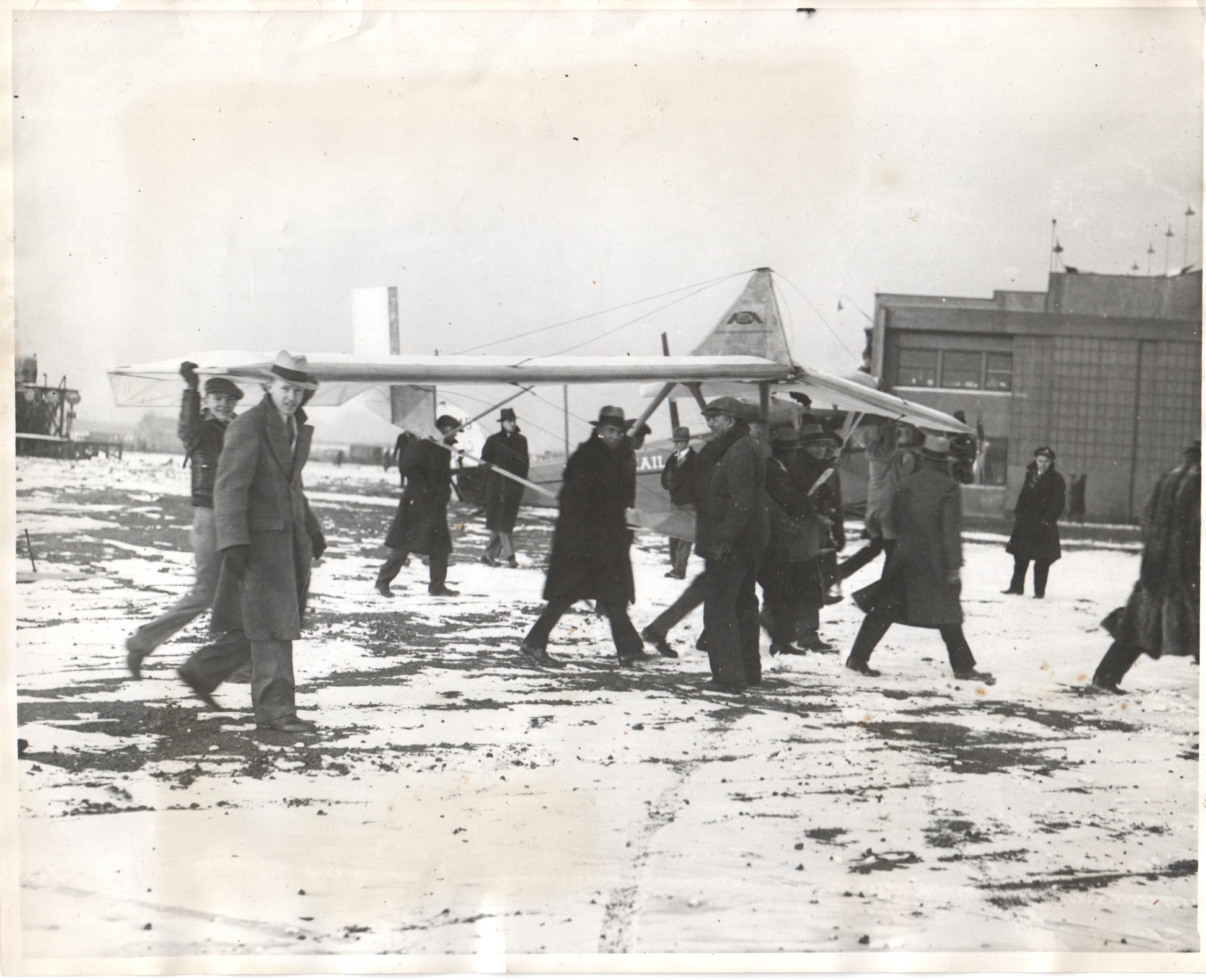 Early aviators carrying a glider in a snowy setting. - Image: Folder17-15