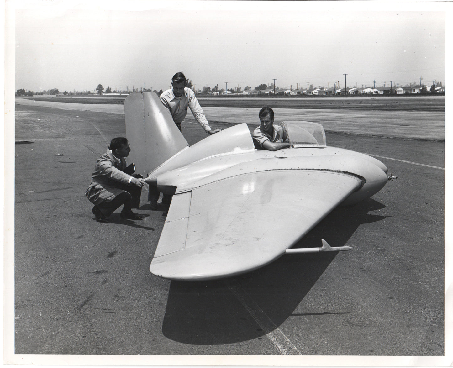 Engineers inspecting a vintage aircraft prototype on the runway. - Image: Folder26-10