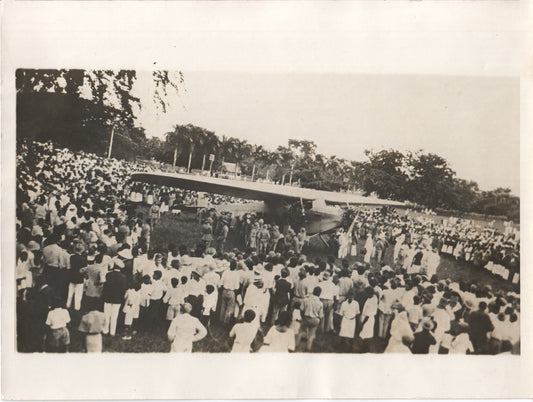 Photo of a large crowd gathered around a vintage airplane celebration. - Image: Folder19-3