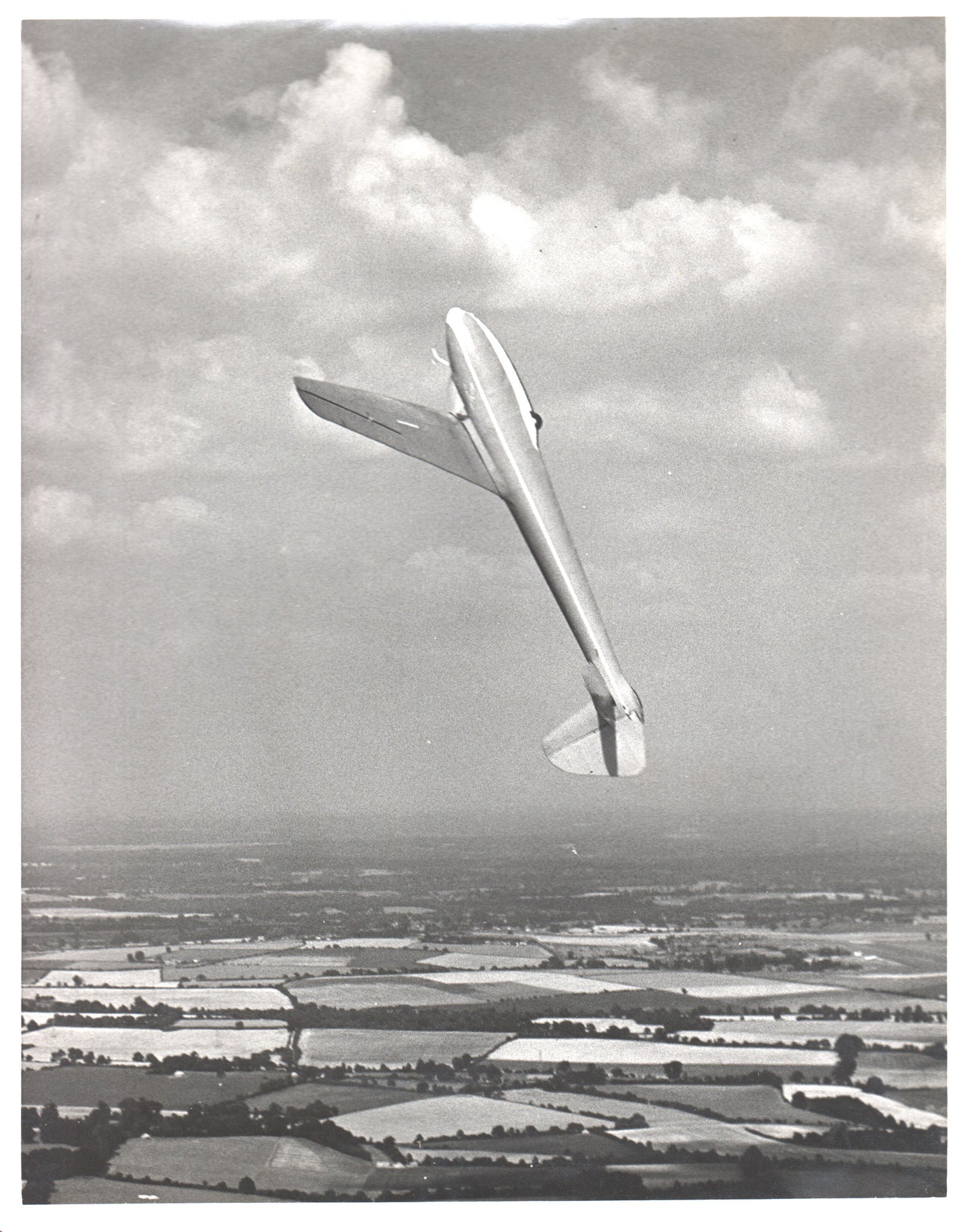 A vintage black and white photo of a glider flying against a cloudy sky. - Image: Folder3-13