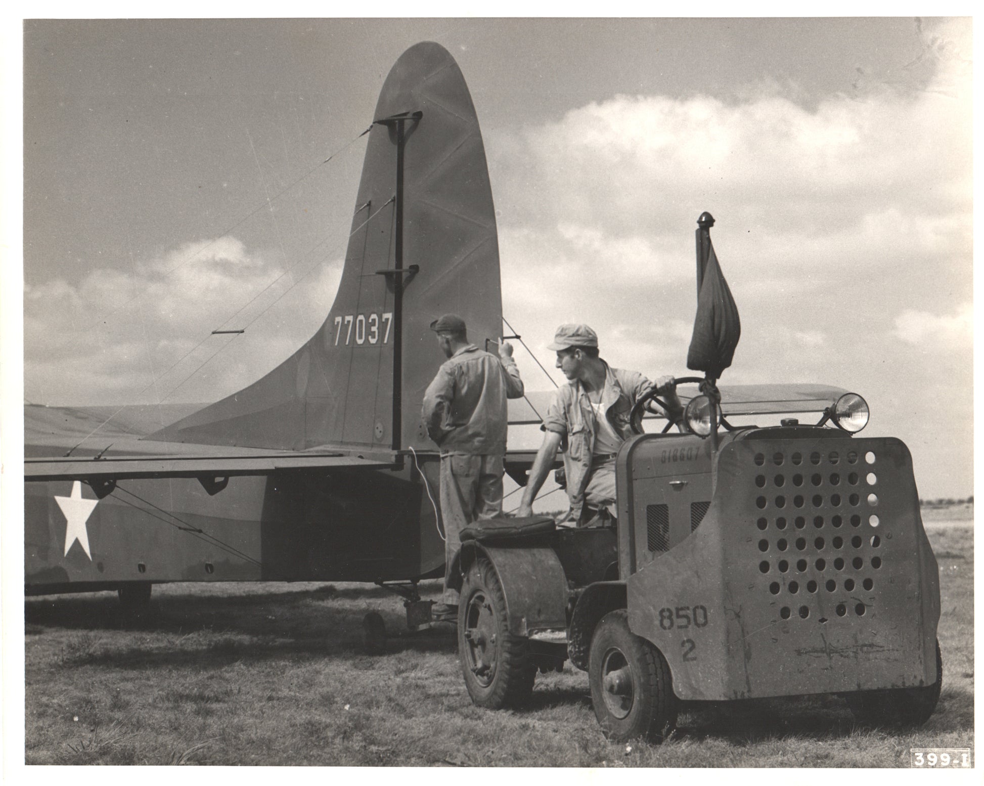 Black-and-white photograph of WWII aircraft ground crew with military tractor. - Image: Folder13-9